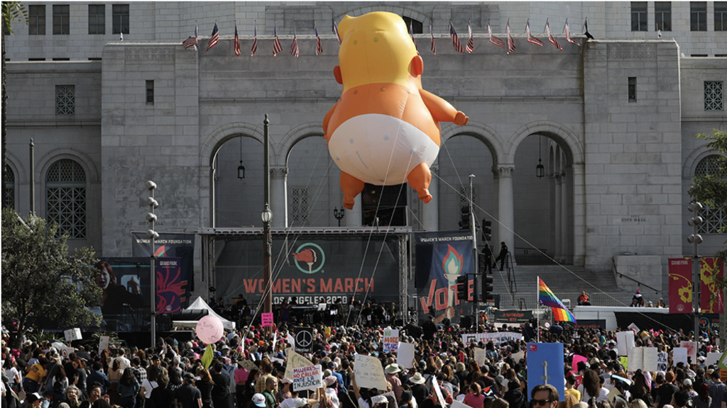 A giant balloon baby floats above the crowd at the 2020 L.A. Women’s March