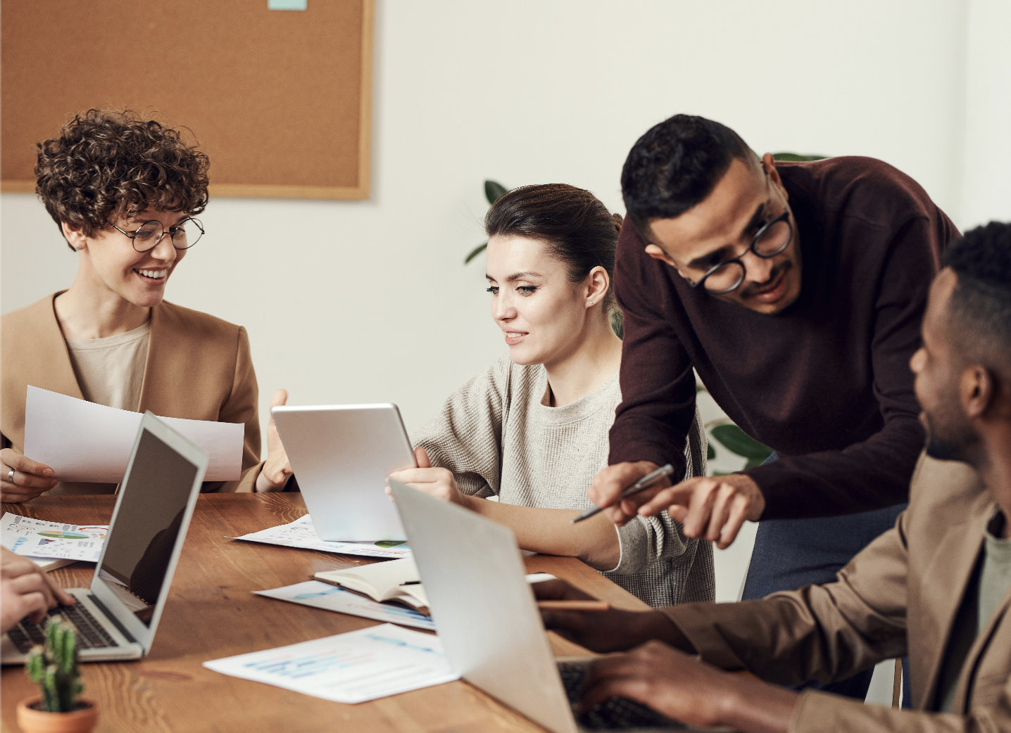 Several people in an office working collaboratively with laptops